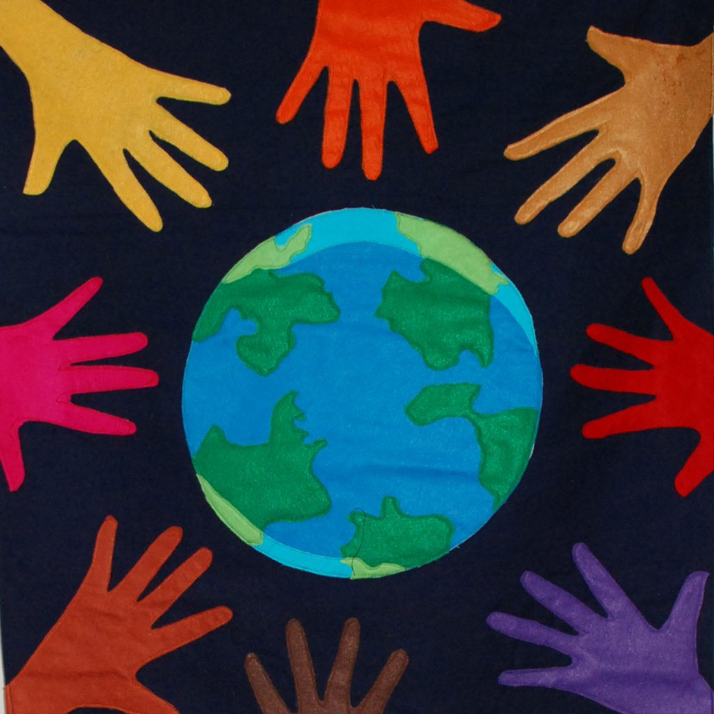 A graphic symbolizing community and connection. A blue and green world graphic with different colored hands surrounding it on a black background.