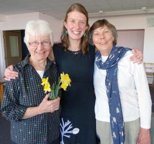 Mary Ellen McElroy, at left, and Martha Crawley, at right, welcome Jessie Rathburn at her April 3 co-membership celebration. (Photo by Lisa Reynolds)