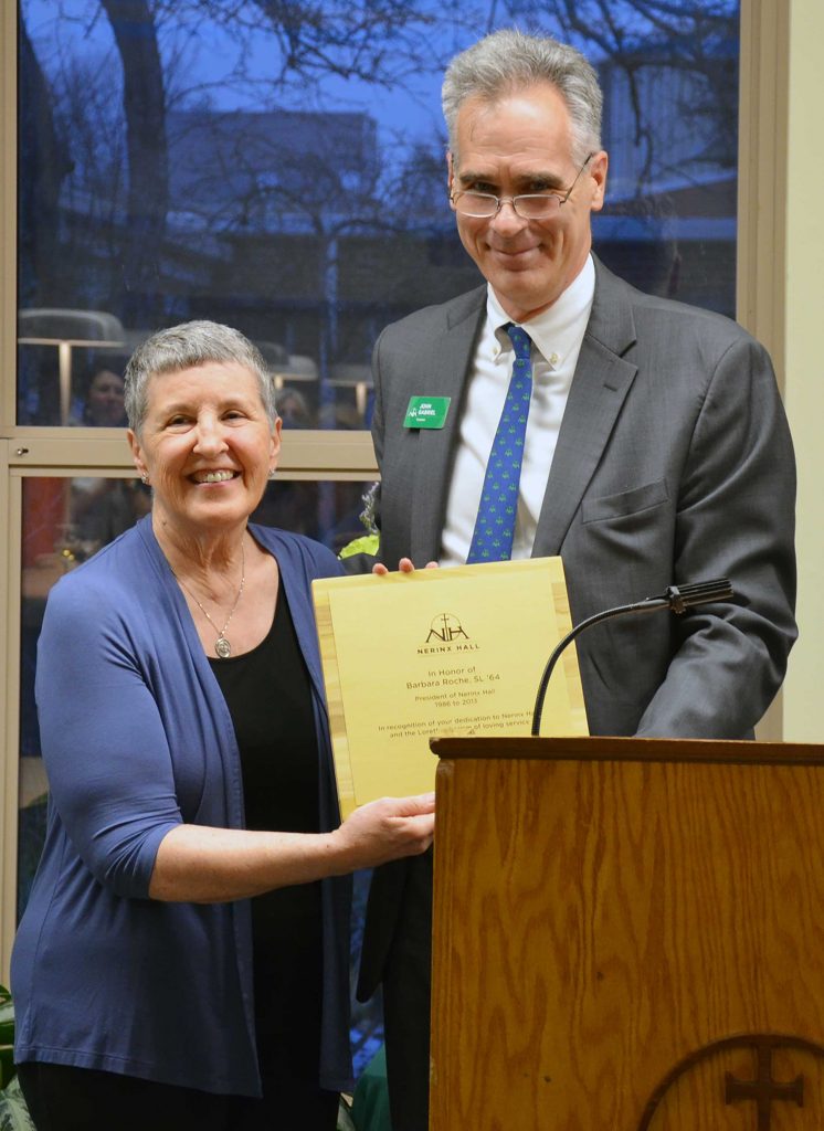 Barbara Roche, with Nerinx Hall President John Gabriel by her side, proudly accepts the dedication plaque for the newly remodeled library named in her honor. (Photo by Jean M. Schildz)