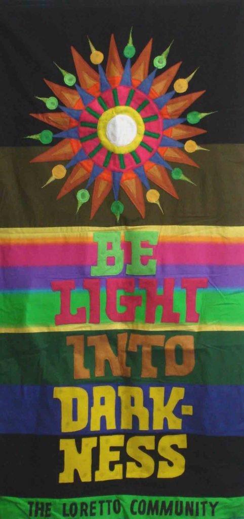 Colorful banners reads, "Be light into darkness — The Loretto Community."