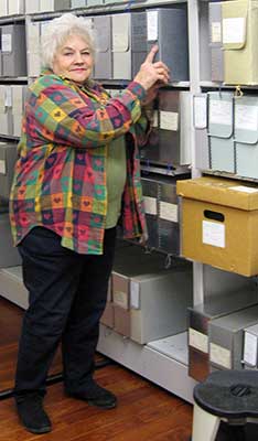 Heritage Center Assistant Marcia Mohin relocates file boxes on the new moveable shelves. (Photo courtesy of Eleanor Craig)