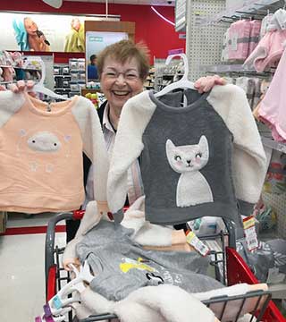 A smiling Vivian Doremus enjoys selecting clothing for refugee children. (Photo courtesy of Vivian Doremus) 