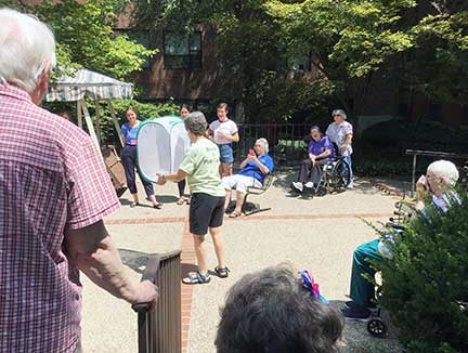 As Motherhouse residents applaud, Joyce Minkler releases monarch butterflies onto the Motherhouse grounds.  