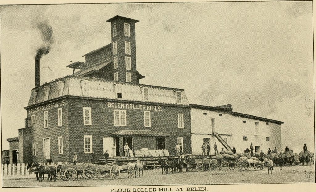Belen, NM Flour mill in 1904. Horses, carts and workers in front of the mill.
