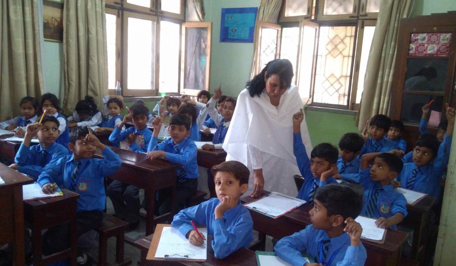 Maria Daniel SL is shown working with students in a classroom.