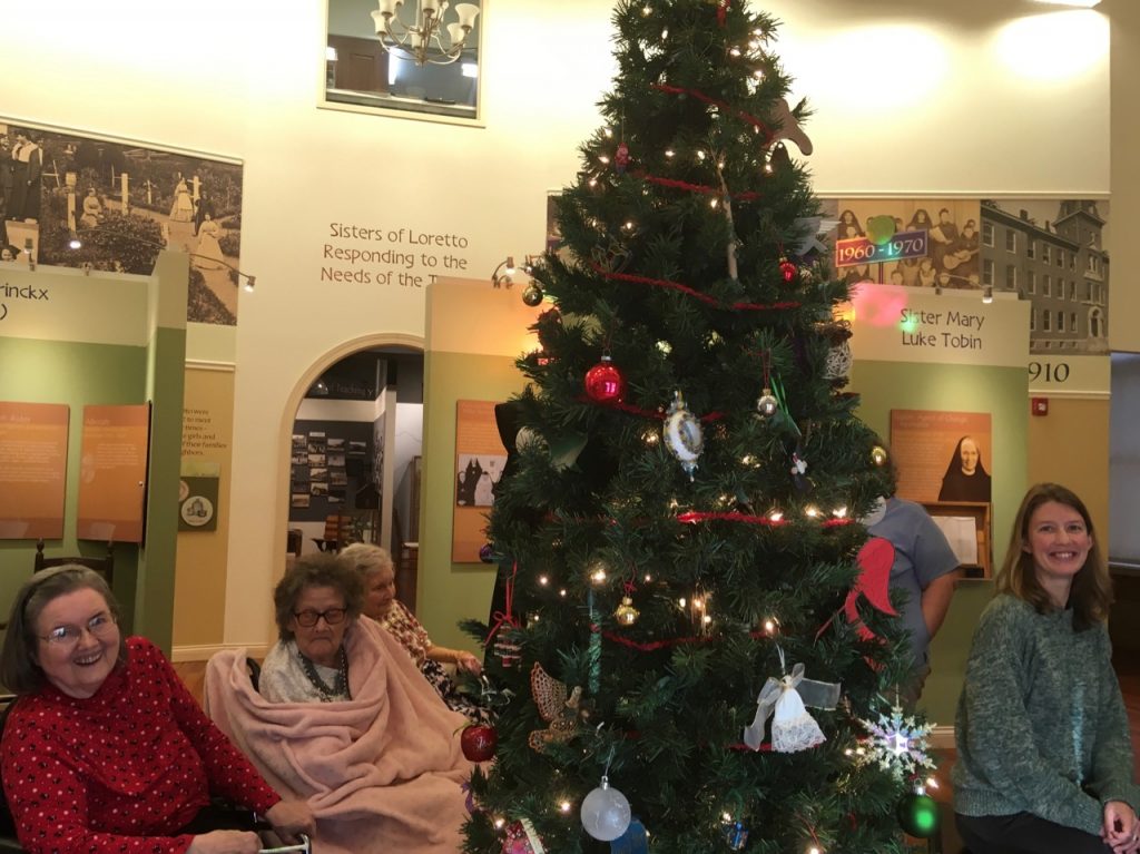 Residents of the Motherhouse Infirmary and Loretto staff around a Christmas tree in the Heritage Center