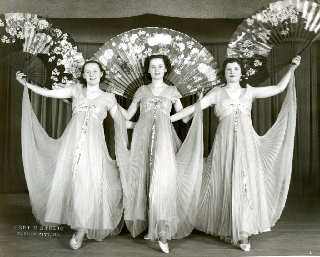 Three female students pose before their dance recital