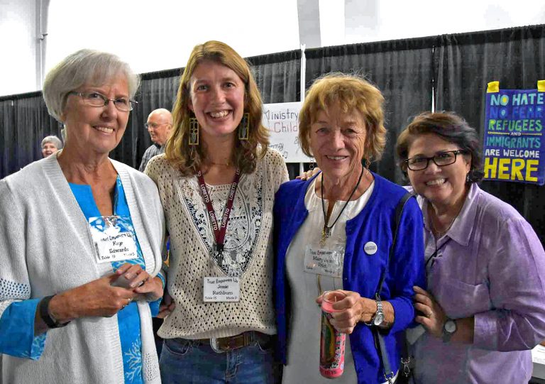 Four co-members stand together at a Loretto Assembly