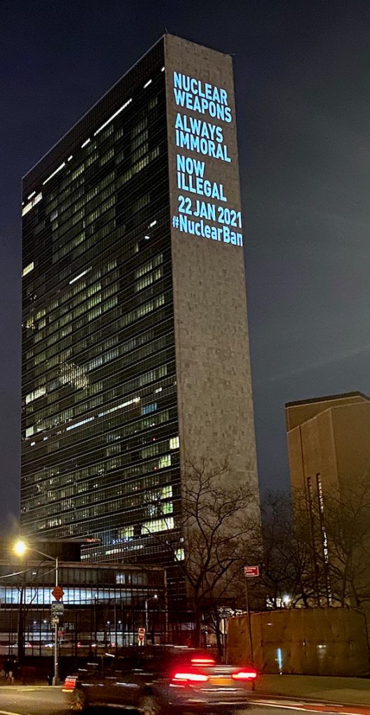 A tall office building displays the words "Nuclear Weapons Always Immoral Now Illegal 22 Jan 2021 #NuclearBan" on its side.