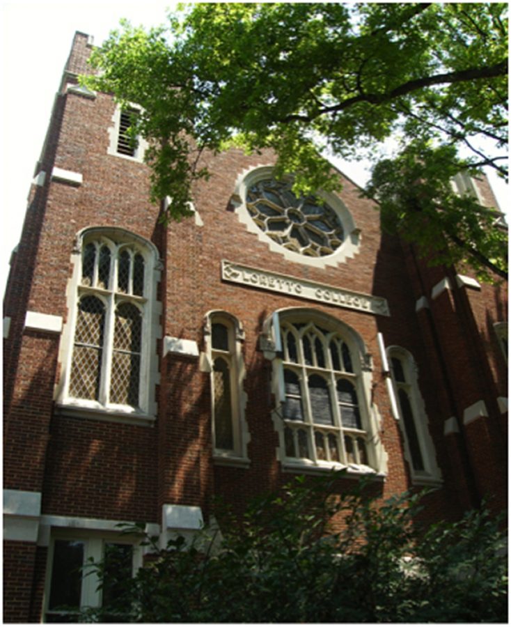 Looking up at a large brick building with "Loretto College" carved across the front, under an ornate rose window.