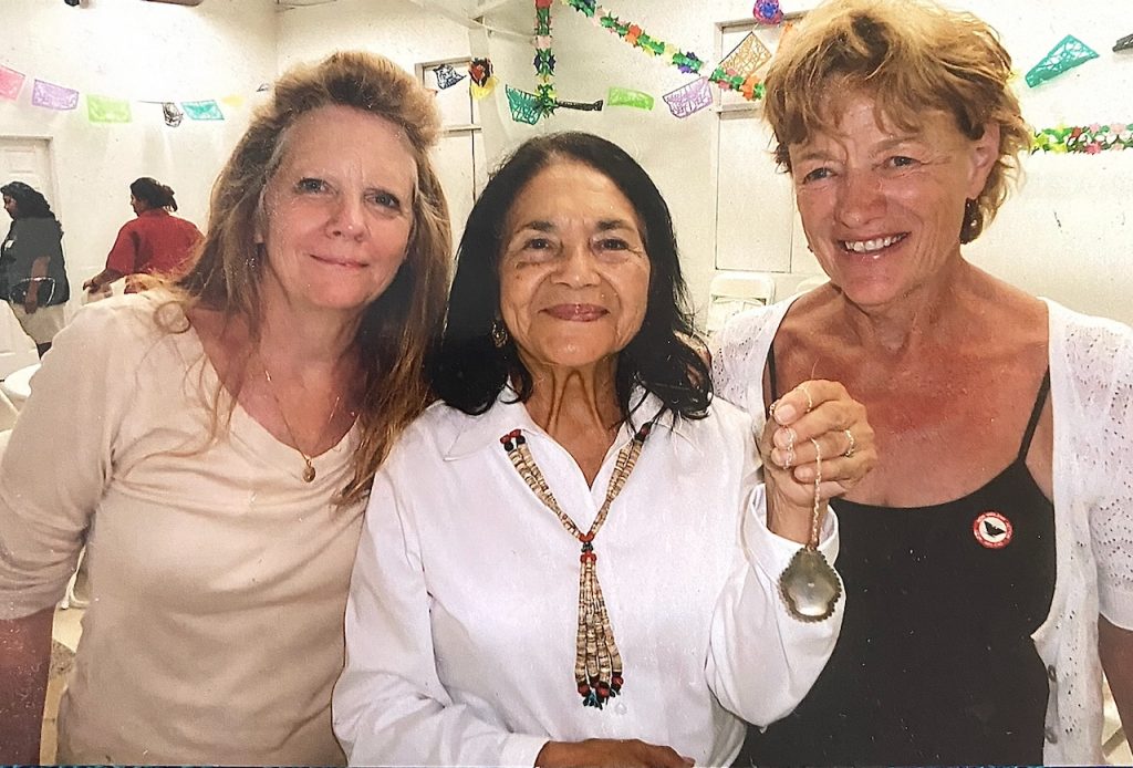 Three women lean in for a photo together at a celebration