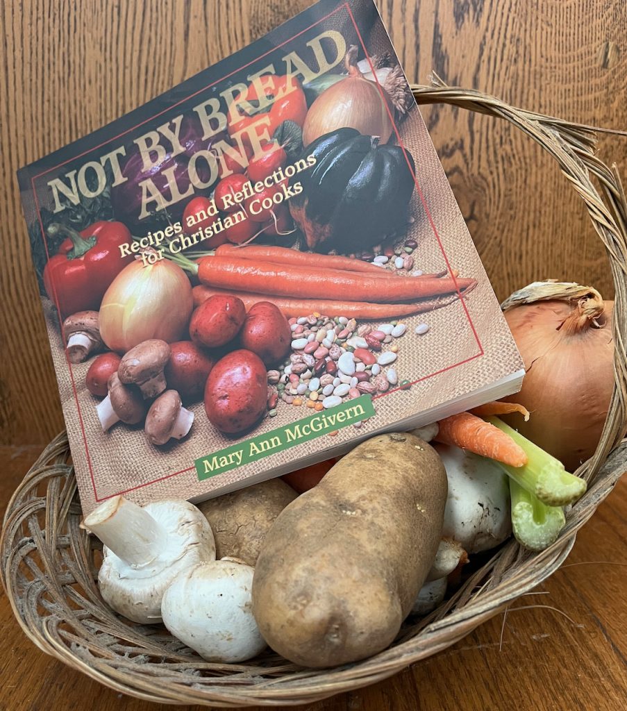 Recipe book sits on the top of a basket of vegetables