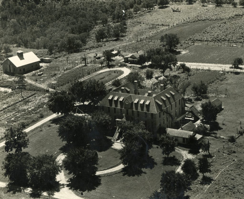 Arial view of a large, square building in a rural area.