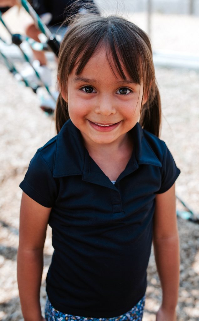 A little girl smiles into the camera.