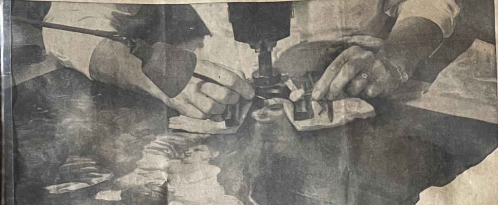 Newspaper photograph of conservation work being done on the painting