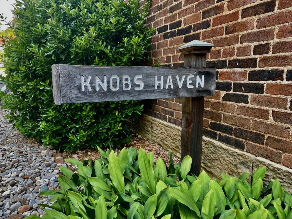 A carved wooden directional sign reads "Knobs Haven."