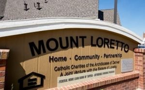 Sign outside building reads "Mount Loretto: Home. Community. Partnership" Subheading: Catholic Charities of the Archdiocese of Denver. A Joint Venture with the Sisters of Loretto.