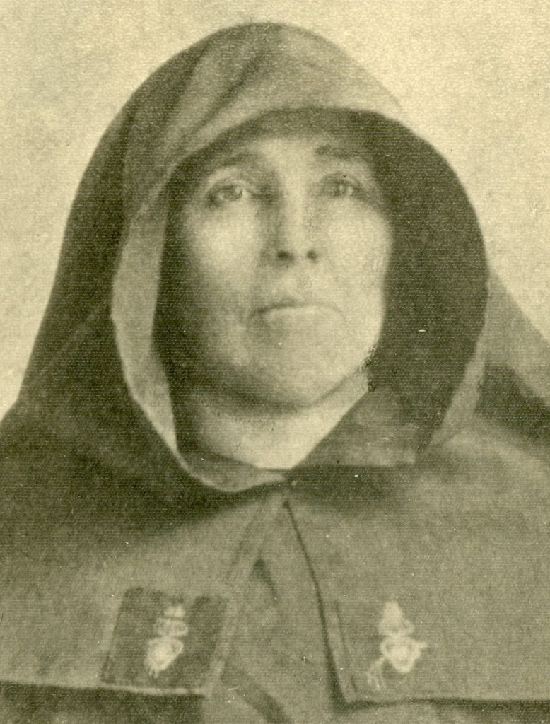 Archival black-and-white photo of a nun in a habit with the sacred heart sewn to the veil.