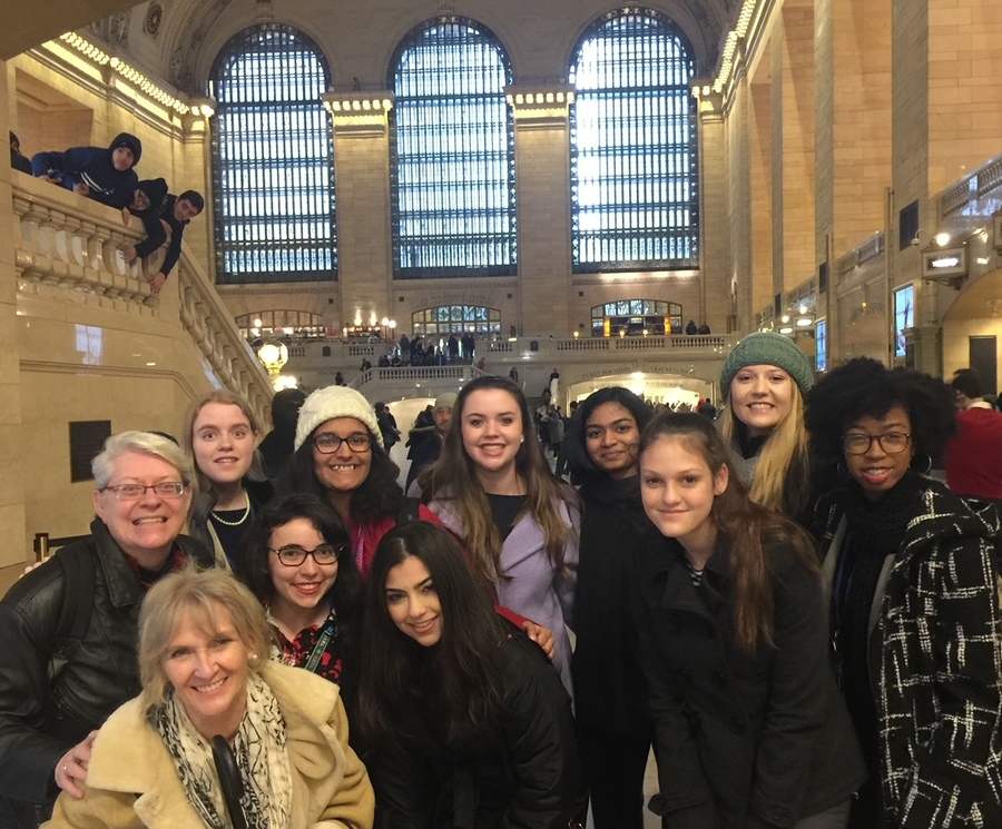 A group of people lean in for a photo in a large, high ceiling-ed space.