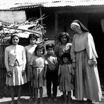 A nun in habit poses for a photo with a Chilean family in this archival photo