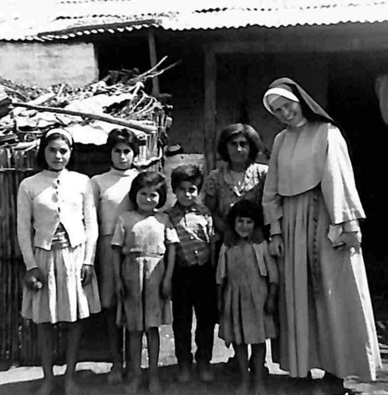 A nun in habit poses for a photo with a Chilean family in this archival photo