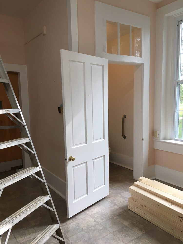 Room with open closet door, step ladder and stack of boards