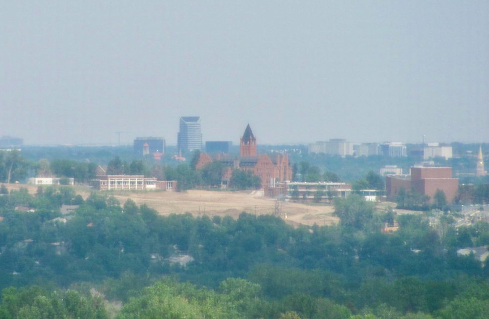 The tower of a red brisk building is visible on the hill in the distance.