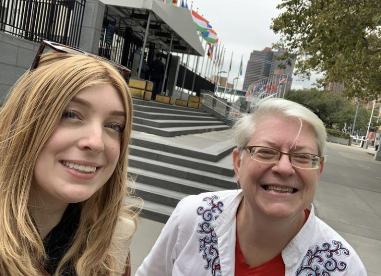 A younger, and older women taking a selfie together in a city