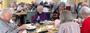 Five women conversing happily over a meal.
