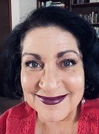 Selfie of Terry Franco, a woman with short black hair, wearing dark purple lipstick and a red shirt.