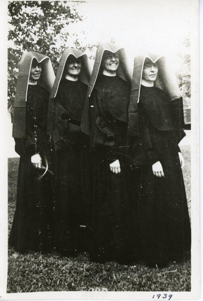 Archival photo of four habited nuns posing together. A family resemblance is visible among members of the group.