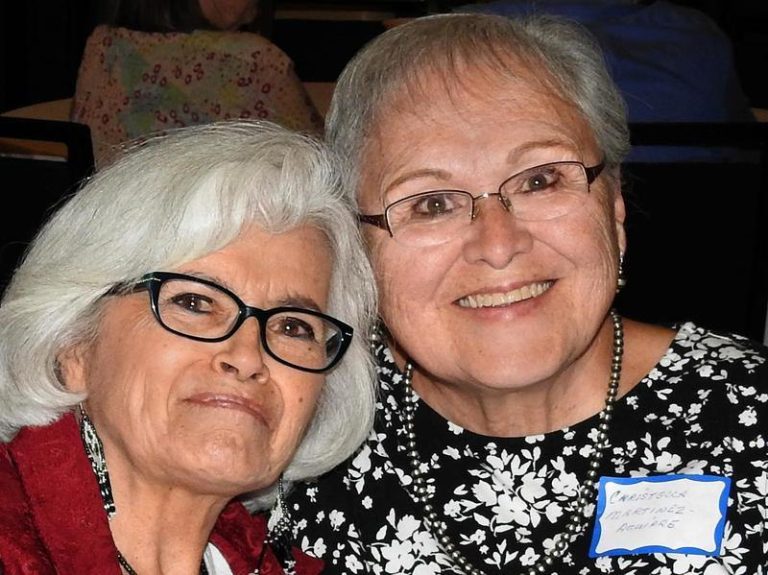 Two women lean in for a photo together.