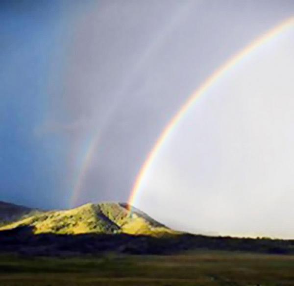 Double rainbow over a mountain landscape.