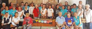 A culturally diverse gathered in support of immigrants smiling together for a large group photo.