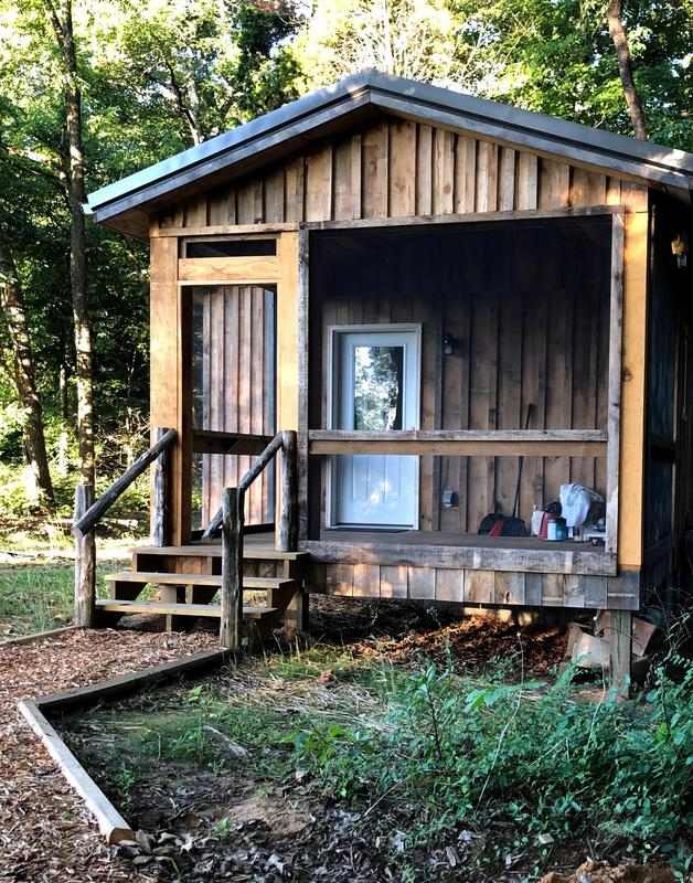 Small wooden cabin with a front porch.