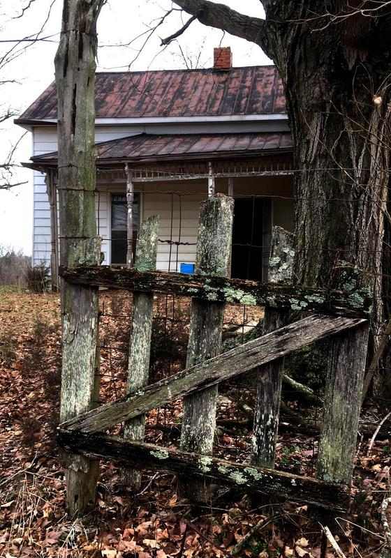 View looking through an old wooden gate of an old house.