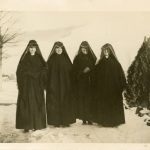 Four Sisters of Loretto stand side by side in the snow in heart shaped habits.