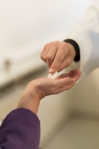 a person giving communion bread on hand