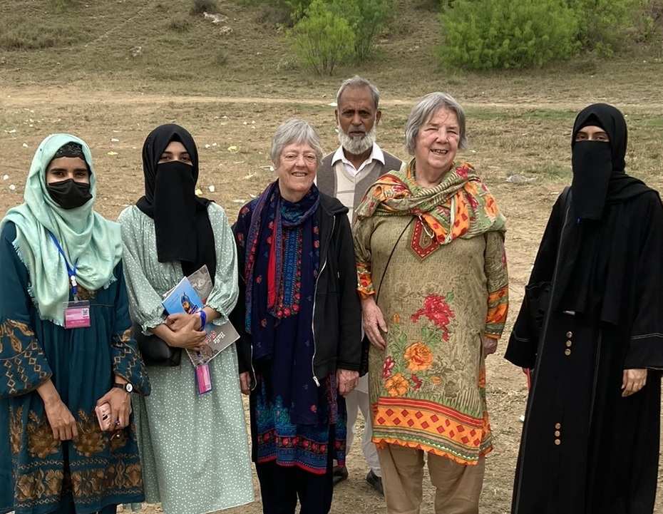 Six people gather outside for a photo