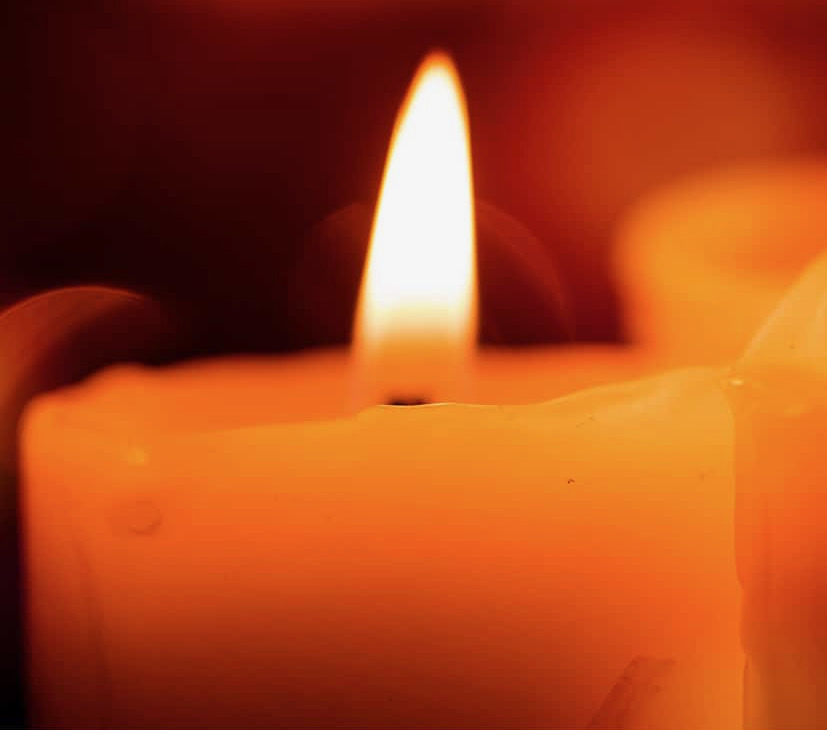 A close-up view of a candle flame emitting an orange glow.
