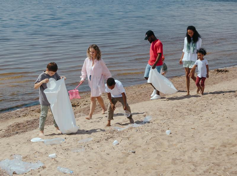 A family of 6 work together to clean up plastic waste off a beach.