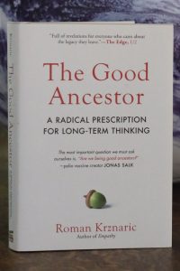 A book cover titled "The Good Ancestor: A Radical Prescription for Long-Term Thinking by Roman Krznaric"