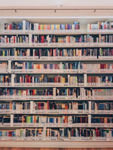 A large shelf with nine rows contains colorful library books.