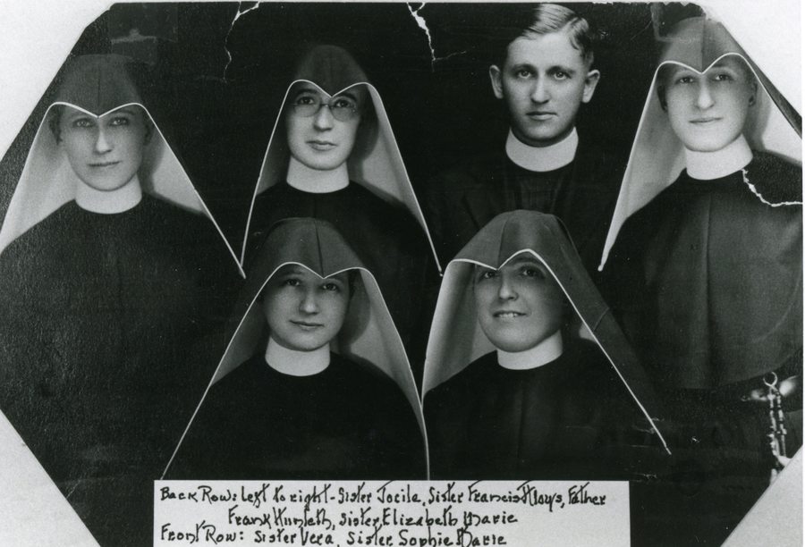 Archival family photo of five women in habits and one man in a priest's collar.