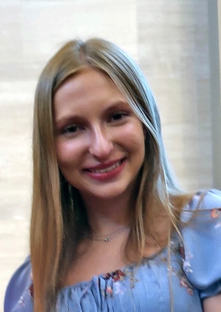 Photo of a young white woman with blonde/brown hair smiling.