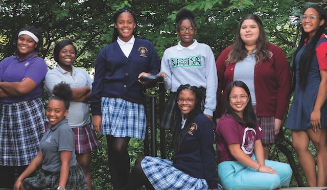 Marian Middle School students (wearing dark blue uniforms) spend time with graduates (wearing their current high school uniforms).