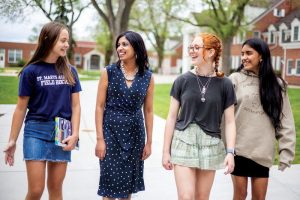 Three St. Mary's Academy students of diverse backgrounds walk the campus with St. Mary's Academy President, Ms. Iswari Natarajan.