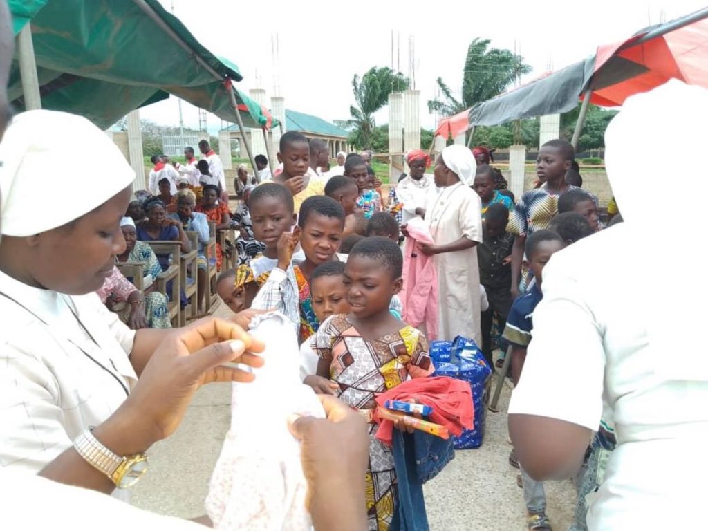 FST Sisters in white habits pass out donated clothing to local children.