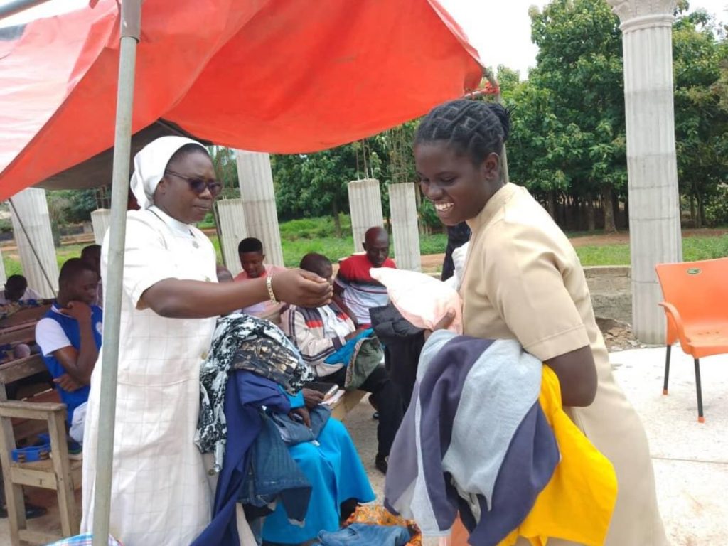 Two FST sisters holding donated clothing preparing to give it away to people who need it.