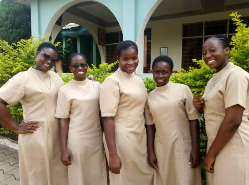 Photo of five Ghanaian FST postulants smiling all dressed in light brown/tan dresses